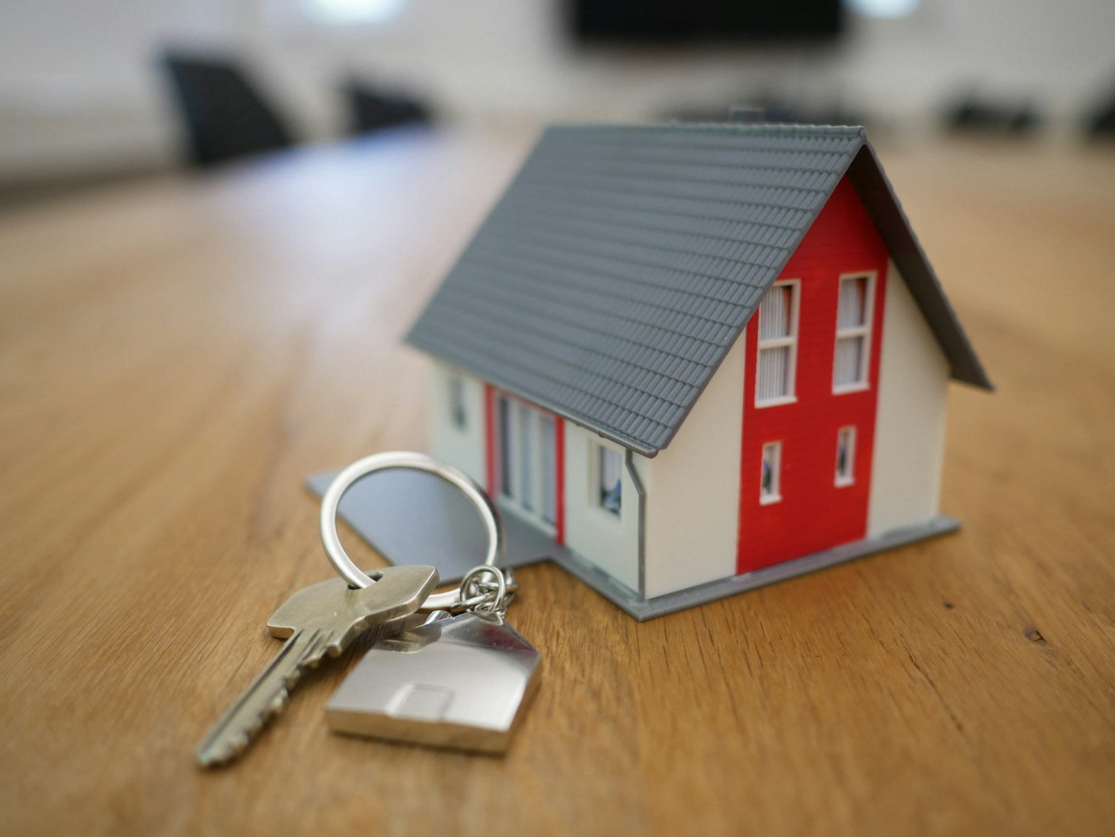 Maqueta de una casa con sus llaves sobre una mesa