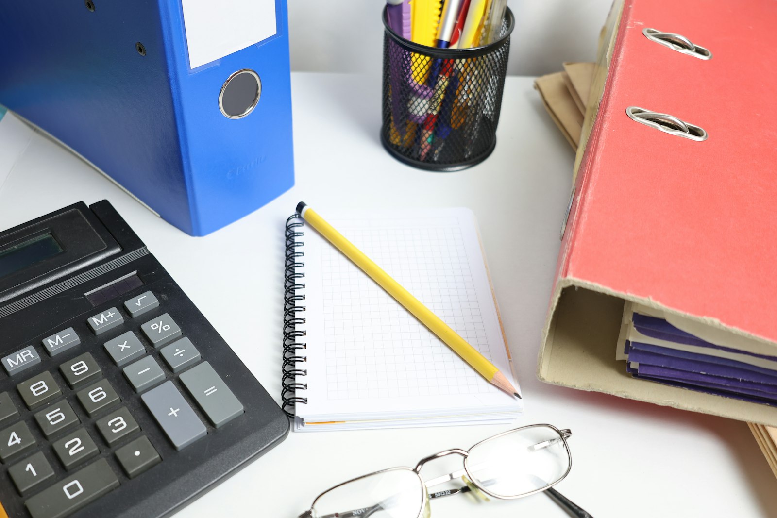 Escritorio con calculadora, carpetas y libreta para llevar las cuentas